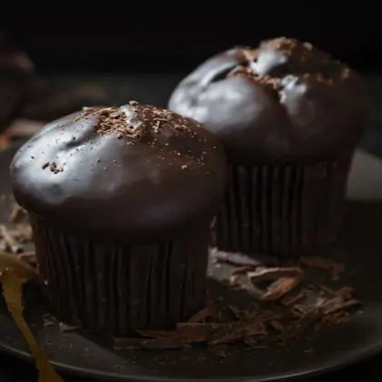 Muffin con chispas de chocolate sobre mesa de cafetería